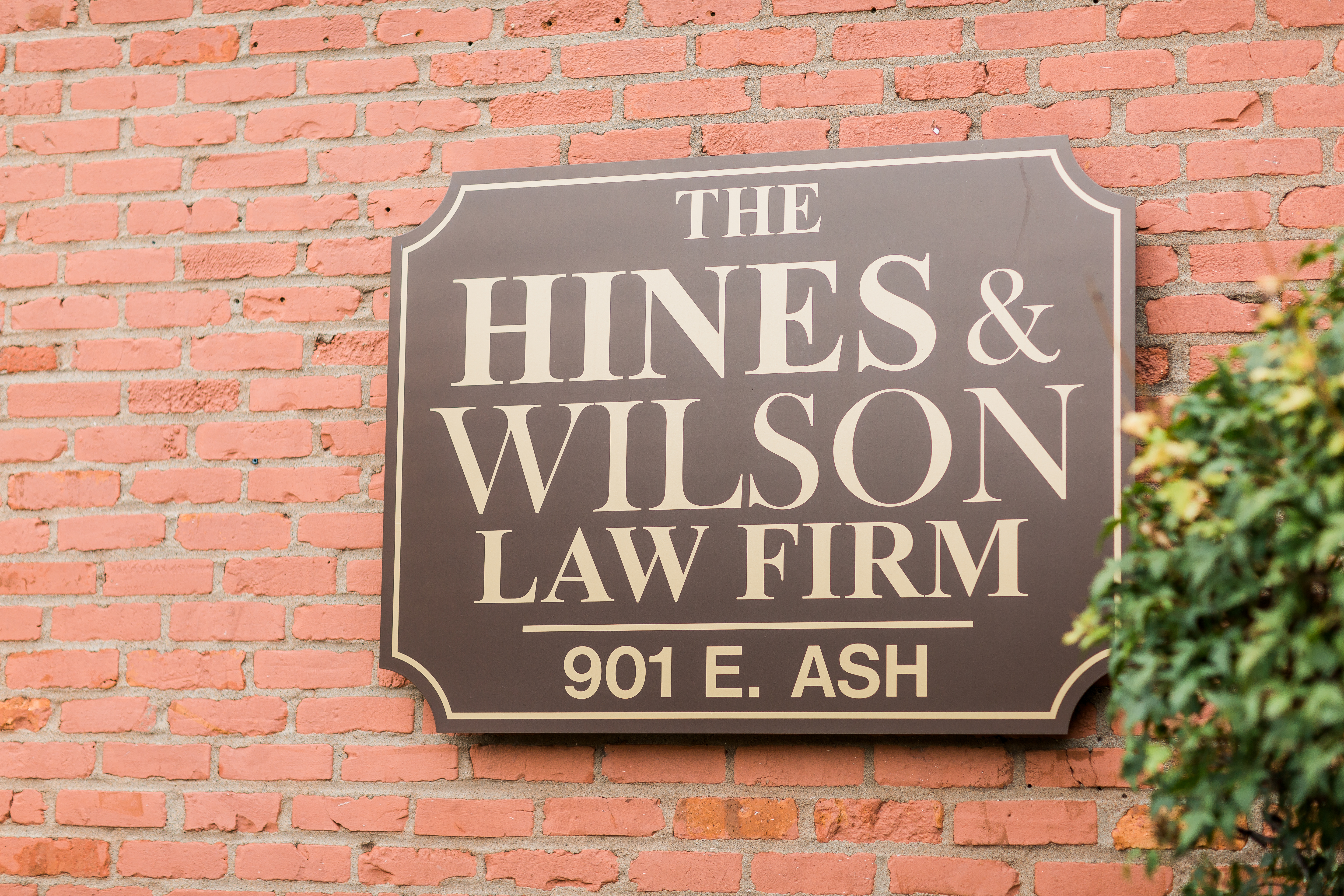 the hines & wilson law firm sign on the side of a brick building