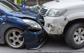 the front of a blue car and white SUV involved in a head on collision