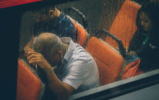 man with head on bus seat head rest through window