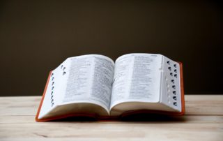 a large open dictionary on a wood desk