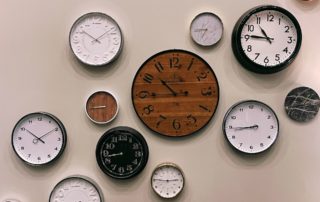 a variety of analog clocks on a wall