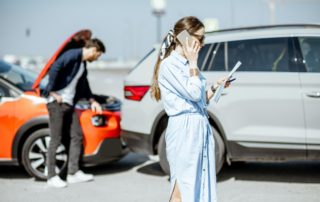 woman on the pho of a fender benderne standing in front