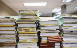 stacks of folders and papers on a desk in an office