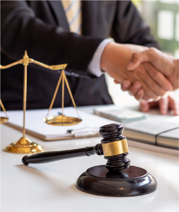 Asset 2 Lawyer shaking hands with a client, gavel and scales of justice on the table, symbolizing legal consultation and support for workers' compensation and legal rights.